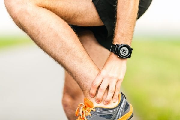 Male Athlete Clutches Ankle in Pain