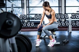 Athlete gripping her arthritic knee