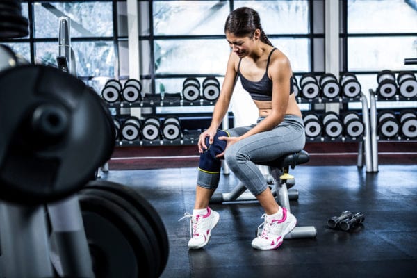 Athlete gripping her arthritic knee